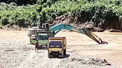 Alat berat dan mobil jenis dumtruk terlihat beroperasi di Sungai Batang Natal pada titik Desa Lancat, Kecamatan Lingga Bayu. (Waspada/ist)