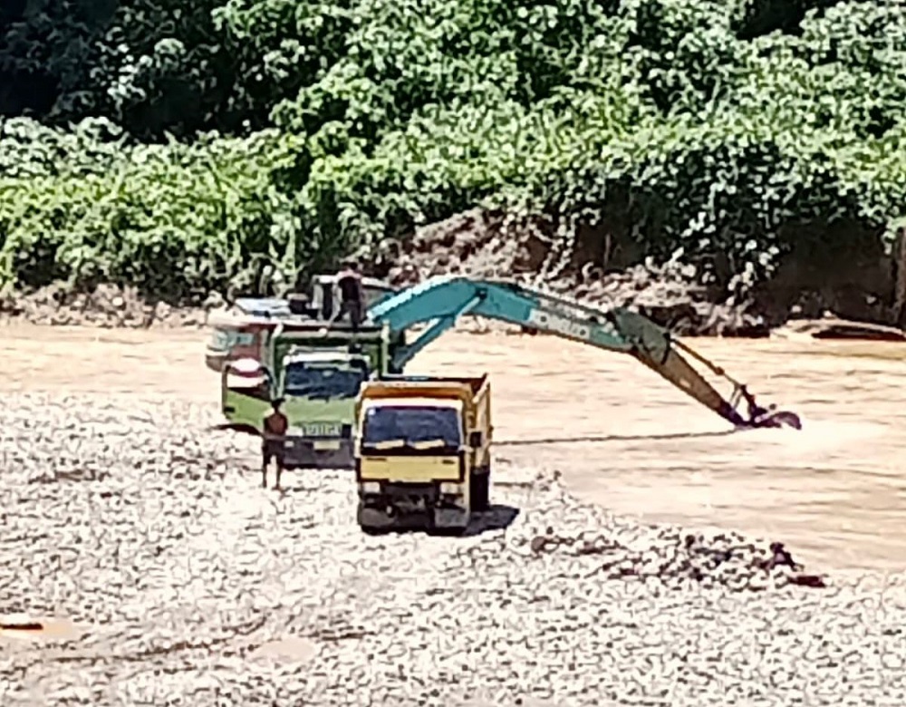 Alat berat dan mobil jenis dumtruk terlihat beroperasi di Sungai Batang Natal pada titik Desa Lancat, Kecamatan Lingga Bayu. (Waspada/ist)