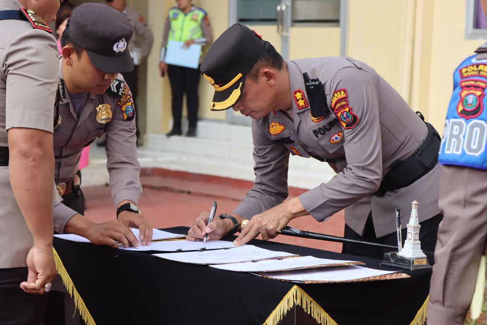 Kapolres Taput, AKBP Ernis Sitinjak SH, SIK saat tanda tangani berita acara pergantian 5 pejabatnya di Lapangan Apel Polres setempat, Sabtu (13/7). Waspada/Ist
