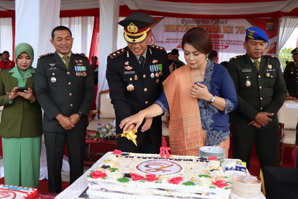 Kapolres Taput, AKBP Ernis Sitinjak bersama istri sedang potong kue HUT Ke- 78 Bhayangkara di Lapangan Serbaguna Tarutung, Senin (1/7). Waspada/Hotbin Purba