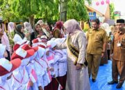 Pj Bunda PAUD Aceh Mellani Subarni bersalaman dengan murid baru saat berkunjung di SDN 1 Lampeuneurut, Kecamatan Darul Imarah, Aceh Besar, Senin (15/7). (Waspada/Ist)