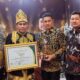 Ketua Posyantek Naturi, Faisal didampingi Kepala DPMG Provinsi Aceh usai menerima Piala Juara Favorit Nasional pada Lomba Teknologi Tepat Guna Nasional (TTGN) ke-25 di Lapangan Islamic Center Mataram, Nusa Tenggara Barat (NTB), Senin (15/7). (Waspada/Ist)