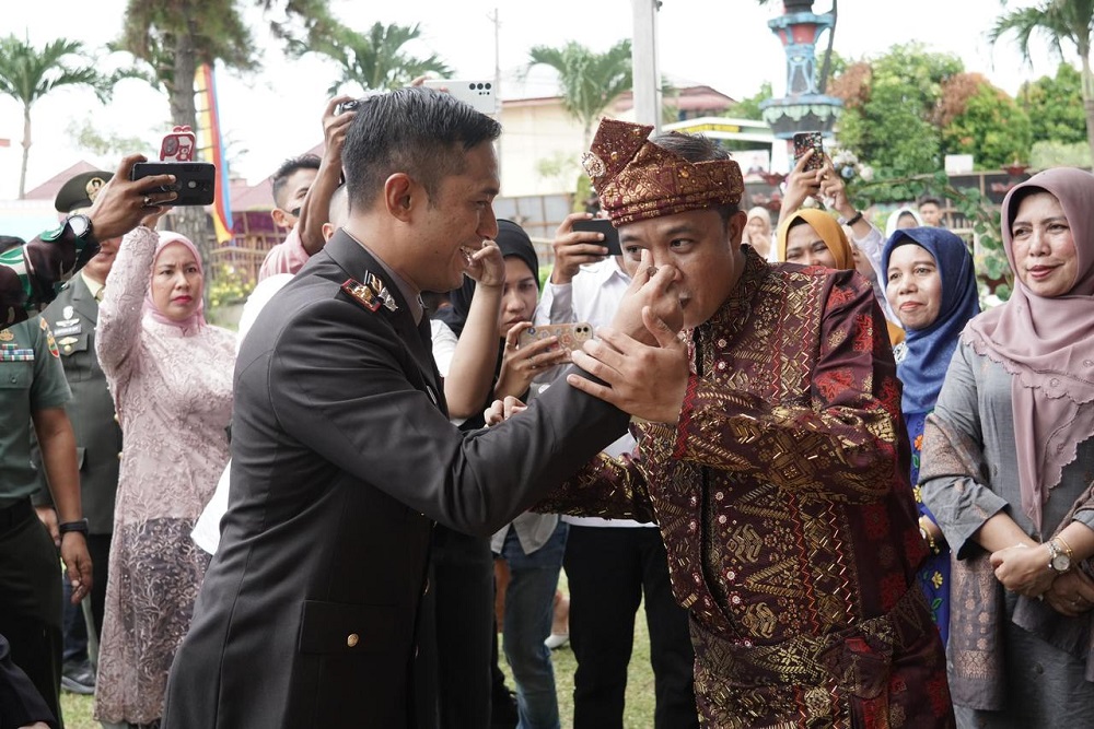 Pj Wali Kota Tebingtinggi, Dr Moettaqien Hasrimi, S.STP, M.Si ketika disuapi oleh Kapolres Tebingtinggi, AKBP Andreas LJ Tampubolon. Waspada/Kristian Brahmana