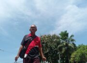 Seorang pedagang jajanan keliling berjalan kaki di bawah terik panas matahari di Jalan Veteran, Binjai Kota. (Waspada/Ria Hamdani)
