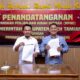 Pj Bupati Aceh Tamiang, Drs. Asra Ketua Panwaslih Pilkada Kabupaten Aceh Tamiang, Rudiansyah saat menandatangani NPHD senilai Rp6,7 M yang berlangsung pada Sabtu (13/7) malam di ruang kerja Bupati setempat. (Waspada/Yusri).
