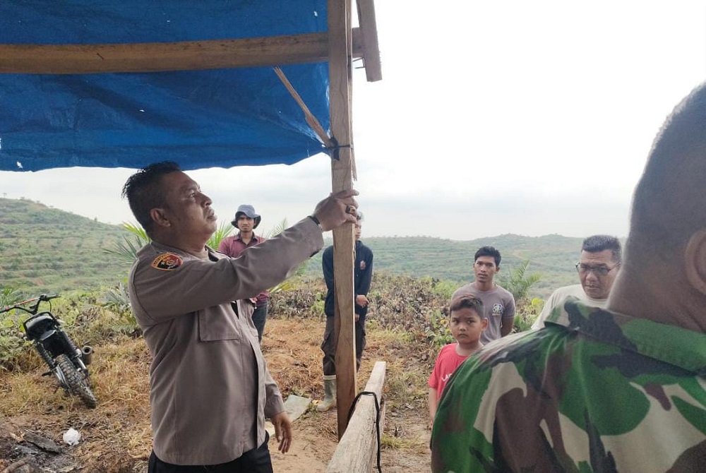 Polisi bersama warga mengamati pondok dijadikan tempat berlindung dua Satpam PT Bumi Flora yang disambar petir di Alue Lhok, Idi Tunong, Aceh Timur, Senin (29/7). Waspada/H. Muhammad Ishak