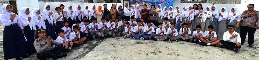 Kasat Binmas Polres Pematangsiantar AKP Jahrona Sinaga (pakaian dinas tengah berdiri) melaksanakan Police Go To School di SMA dan SMP Swasta Erlangga, Jl. Merdeka, Senin (29/7) dan berkesempatan foto bersama usai kegiatan.(Waspada-Ist).
