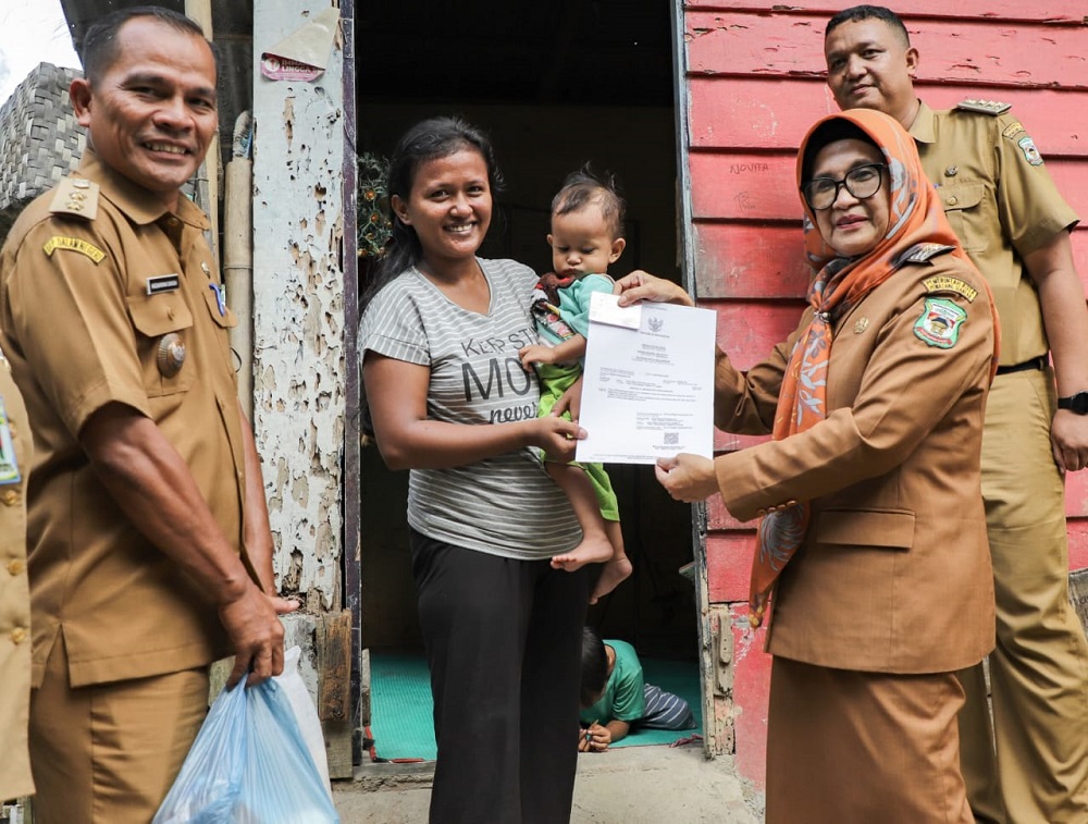 Wali Kota Pematangsiantar Susanti Dewayani menyerahkan secara langsung bantuan pangan, kartu BPJS Kesehatan dan KIA kepada keluarga berisiko stunting dan memiliki anak stunting di Jl. Bah Birong Ujung, Kel. Sigulanggulang, Kec. Siantar Utara, Selasa (30/7) sore.(Waspada-Ist).
