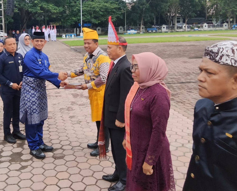 Pj.Bupati Deliserdang Ir.Wiriya Alrahman, MM, menyerahkan Keppres kepada Kepala BKPSDM Deliserdang Drs.M.Abduh Rizali Siregar, MSi, yang menerima tanda kehormatan SKS XXX Tahun pada Upacara Hari Jadi ke 78 Kabupaten Deliserdang Tahun 2024 di Alun-alun Pemkab Deliserdang, Senin (1/7). (Waspada/Khairul K Siregar/B)