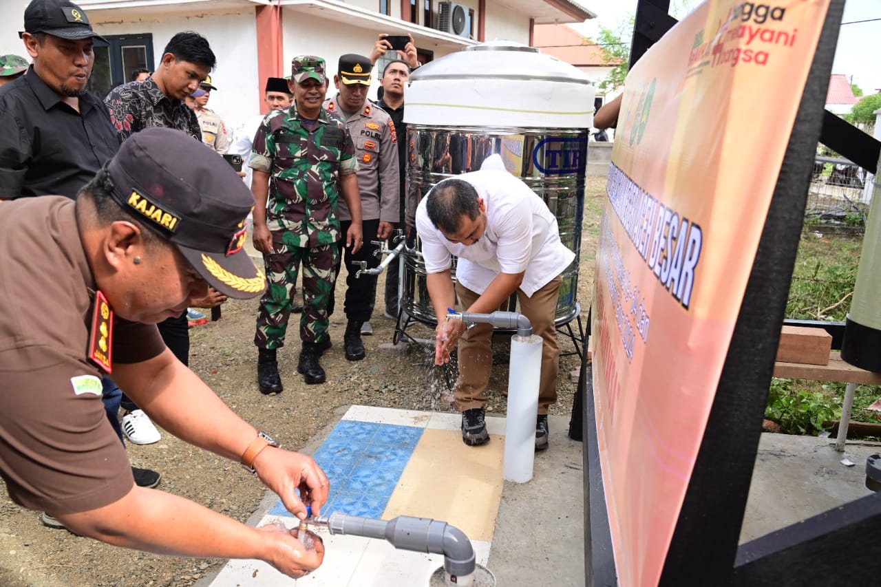 Pj Bupati Aceh Besar Muhammad Iswanto dan Kajari Aceh Besar Basril G SH MH membuka kran sumur bor di Gampong Meunasah Mesjid Lampuuk, Kecamatan Lhoknga, Aceh Besar, Jum'at (19/7). (Waspada/Ist)