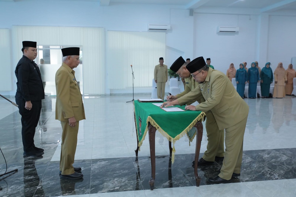 Bupati Asahan Surya saat menyaksikan Sekda Asahan Jhon Hardi Nasution yang kini tuntun tahta menjadi Staf Ahli Bupati Asahan penandatanganan pakta integritas ASN saat pelantikan Jabatan Pimpinan Tinggi Pratama di Lingkungan Pemkab Asahan. Waspada/Ist