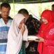 Ummi Salamah menerima bantuan masa panik diserahkan Pj Ketua TP PKK Aceh Besar di Gampong Cot Karieng, Kecamatan Blang Bintang, Aceh Besar Kamis (15/8). (Waspada/Ist)