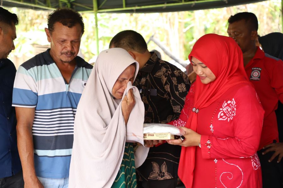 Ummi Salamah menerima bantuan masa panik diserahkan Pj Ketua TP PKK Aceh Besar di Gampong Cot Karieng, Kecamatan Blang Bintang, Aceh Besar Kamis (15/8). (Waspada/Ist)
