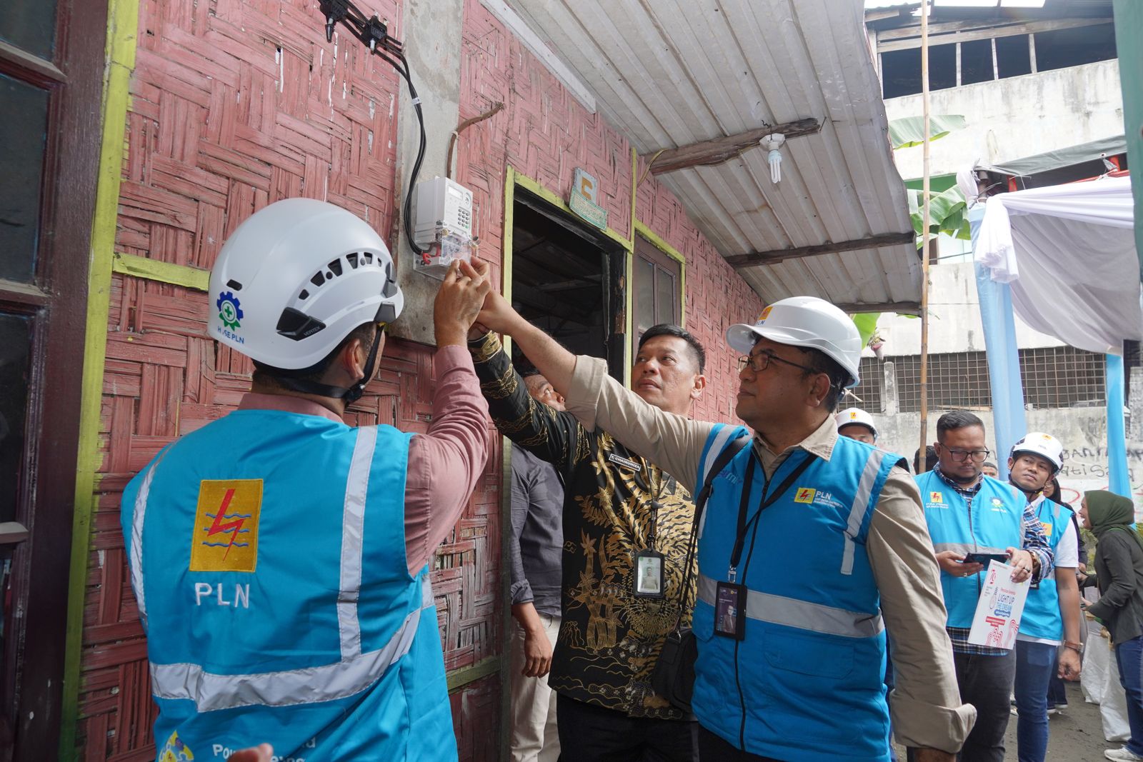 Senior Manager Niaga dan Management Pelanggan, Donny Adriansyah (tengah) bersama Manager PLN Unit Pelaksana Pelayanan Pelanggan (UP3) Medan, Ricky Yacob (kiri) dan Kepala Camat Sunggal, T Chairuniza, S.Sos., MAP (kanan) melakukan penyalaan di rumah salah satu penerima manfaat program LUTD, Kamis (15/8).