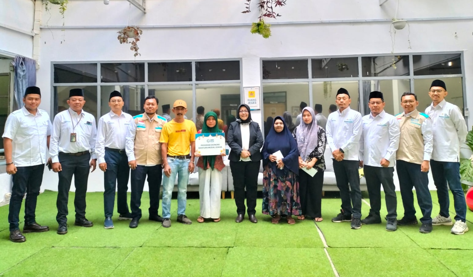 Foto bersama Management PLN UP3 Padangsidimpuan dengan keluarga prasejahtera dalam penyaluran bantuan modal usaha.