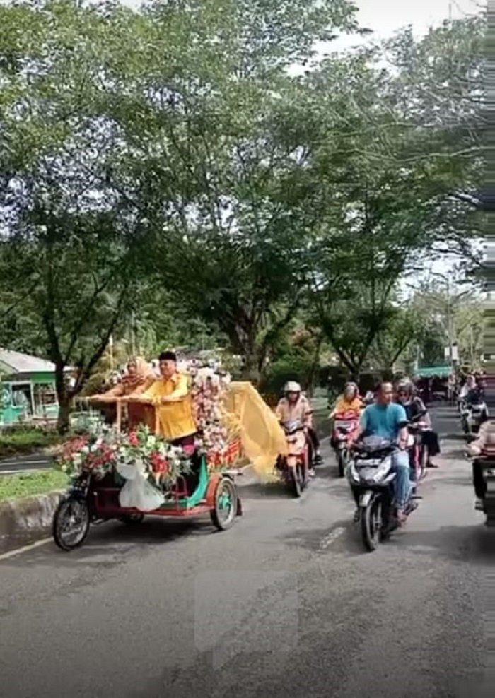 Pasangan Bacabup Afridawati dan Bacawabup Dr. Amin Haris menggunakan beca saat menuju Kantor KIP Simeulue. Rabu (28/8). Waspada/Ist
