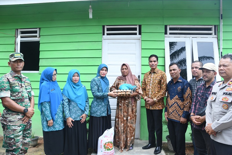 Pj Wali Kota Kota Langsa, Dr (C) Syaridin, SPd, MPd, menyerahkan kunci rumah layak huni kepada Zulfiana warga Gampong Sukarejo, Kecamatan Langsa Timur, Sabtu (31/8). Waspada/Rapian.
