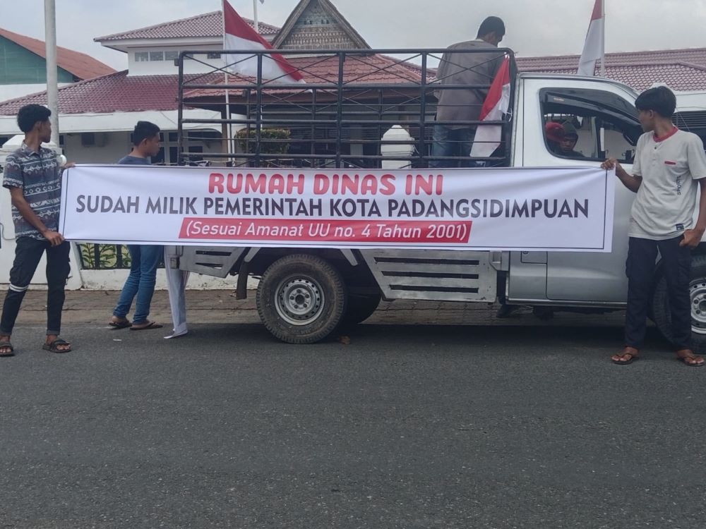 Massa membentangkan spanduk berisi tuntutan aksi, antara lain meminta Bupati Tapsel segera pindah ke rumah dinas baru berbiaya miliaran rupiah di Sipirok. (Waspada/Ist)