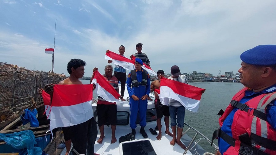 Kasat Polairud Polres Langkat AKP Heru Ediyanto SH membagikan Bendera Merah Putih kepada para nelayan di wilayah pesisir Alur Sei Babalan, Kecamatan Babalan, Kamis (8/8/24). Waspada/ist