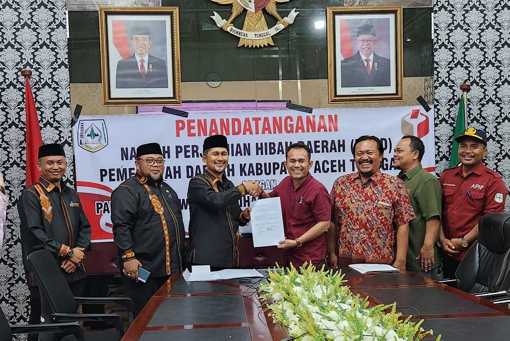 Pj Bupati Syakir bersama Ketua Panwaslih Kaman Sori saat menunjukkan NPHD yang ditandatangani bersama. Waspada/Seh Muhammad Amin