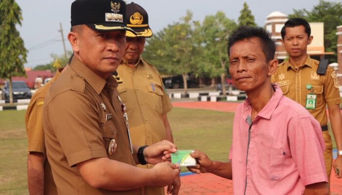 Pj Bupati Paluta Serahkan 976 Kartu BPJS Ketenagakerjaan Kepada Petani Sawit