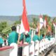 Mahasiswa KKN USK memasang bendera merah putih, di jembatan kawasan Gampong Meunasah Keude, Kecamatan Mesjid Raya, Kabupaten Aceh Besar, Jumat (2/8). (Waspada/Ist)