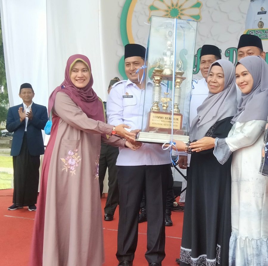 Pj.Sekdakab Deliserdang Dr.H.Citra Effendi Capah, MSP, didampingi Pj.Ketua DWP Chairani CE Capah, Ketua Panitia Drs.H.Syahrul, MPd, menyerahkan Trophy Bergilir Bupati Deliserdang kepada Camat Lubukpakam Rio Laka Dewa, S.STP, M.AP, pada penutupan FSQ ke 46 Tingkat Kabupaten Deliserdang Tahun 2024 di Lapangan Segitiga Lubukpakam, Senin (12/8). (Waspada/Khairul K Siregar/B)