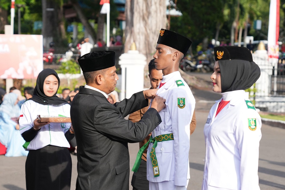 Pj. Wali Kota Sabang, Andri Nourman menyematkan Pin Merah Putih Garuda Paskibraka. (Waspada/ist)