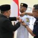 Pj Bupati Aceh Besar Muhammad Iswanto memasang Pin Paskibraka dalam acara Pengukuhan Pasukan Pengibar Bendera Pusaka Paskibraka Kabupaten Aceh Besar Tahun 20204 di Gedung SKB, Kota Jantho, Aceh Besar, Jumat (16/8). (Waspada/Ist)