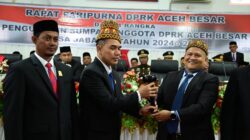 Ketua DPRK terdahulu Iskandar Ali menyerahkan Palu Sidang kepada Ketua DPRK Aceh Besar sementara Abdul Muchti dalam Sidang Paripurna di Kota Jantho, Selasa (20/8). (Waspada/Ist)