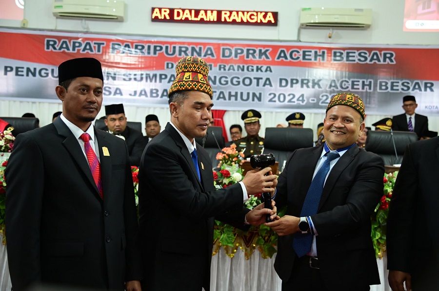 Ketua DPRK terdahulu Iskandar Ali menyerahkan Palu Sidang kepada Ketua DPRK Aceh Besar sementara Abdul Muchti dalam Sidang Paripurna di Kota Jantho, Selasa (20/8). (Waspada/Ist)