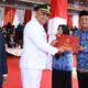 Pj Bupati Aceh Timur Amrullah M Ridha, didampingi Sekda Aceh Timur Ir Mahyuddin MSi, menyerahkan Satya Lencana Karya Satwa (SLKS) ke Marmeam SKep, MKM, usai Upacara Pengibaran Bendera Merah Putih di Lapangan Upacara Pusat Pemerintahan Kabupaten Aceh Timur di Idi, Sabtu (17/8). Waspada/Muhammad Ishak