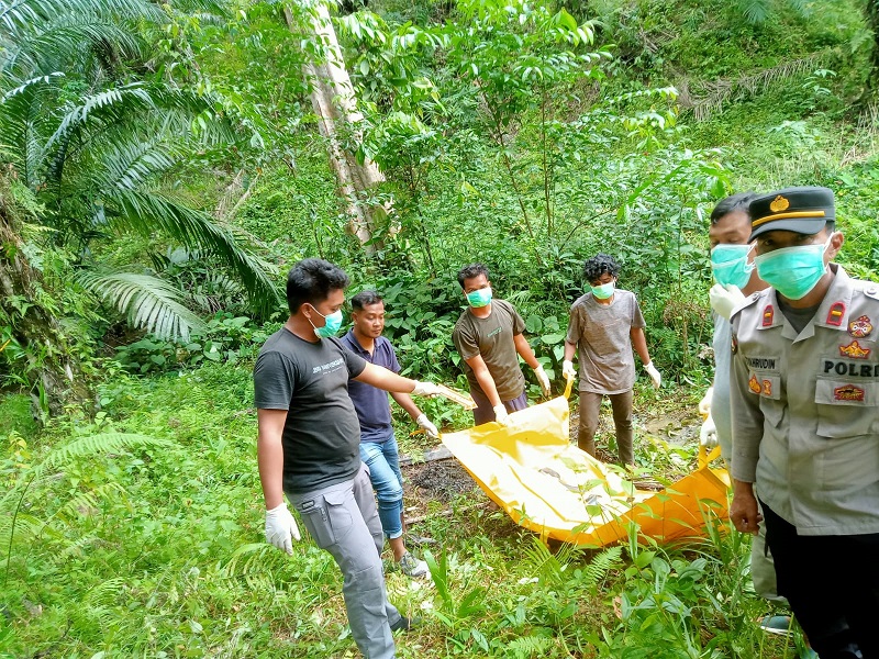 Polisi sedang mengevakuasi mayat korban yang telah membusuk di lokasi perkebunan sawit di Kecamatan Suro, Minggu (25/8). WASPADA/Ist