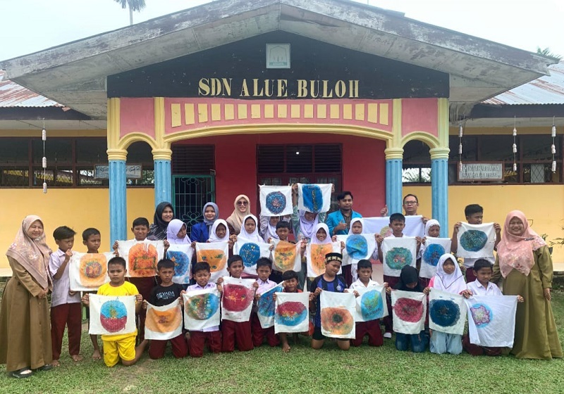 Para siswa SD Negri Buloh memperlihatkan hasil kerajinan membatik saat foto bersama di depan sekolahnya dengan guru dan tim Pengabdian Masyarakat dari Unsam. (Waspada/ Ibnu Sa'dan)
