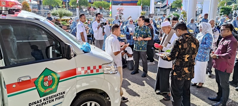Ketua MPU Pidie Tgk H Abu Ismi Iloet didampingi Pj Bupati Pidie Drs Samsul Azhar sedang mempeusijuek (tepung tawar) kendaraan ambulans dan sepeda motor Honda PCX di teras Kantor Bupati Pidie, Kamis (29/8). Waspada/Muhammad Riza