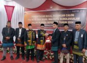 DIDAMPINGI Karlinus (tiga kiri), Fajri Munte menyerahkan berkas Paslon kepada Ketua KIP, Asmiadi. (Waspada/Ist)