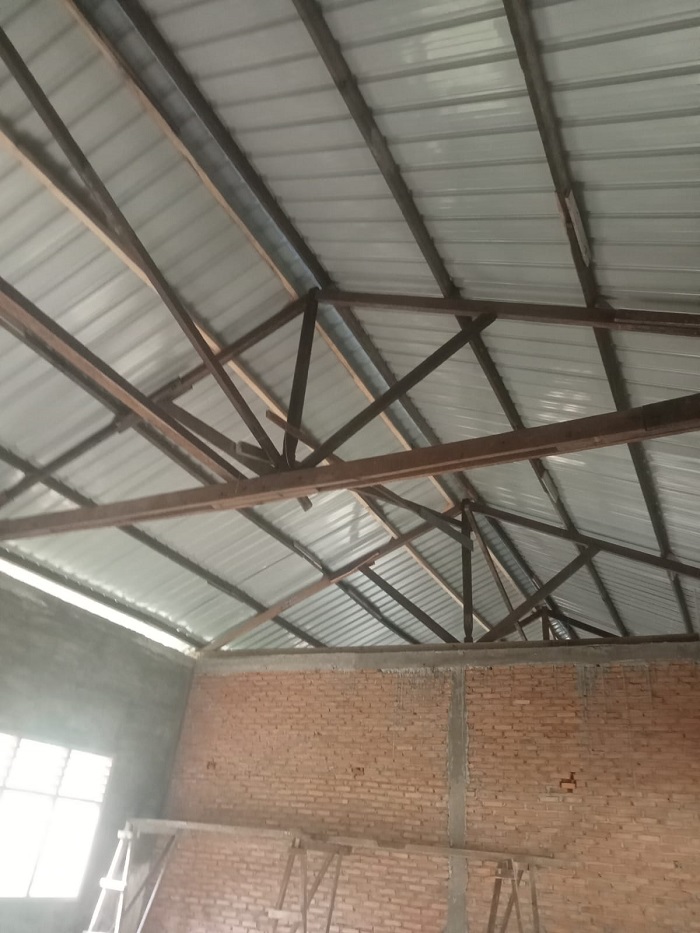 PEMASANGAN atap seng rehab gedung SDN 056033 menggunakan material kayu bekas. Waspada/Asrirrais