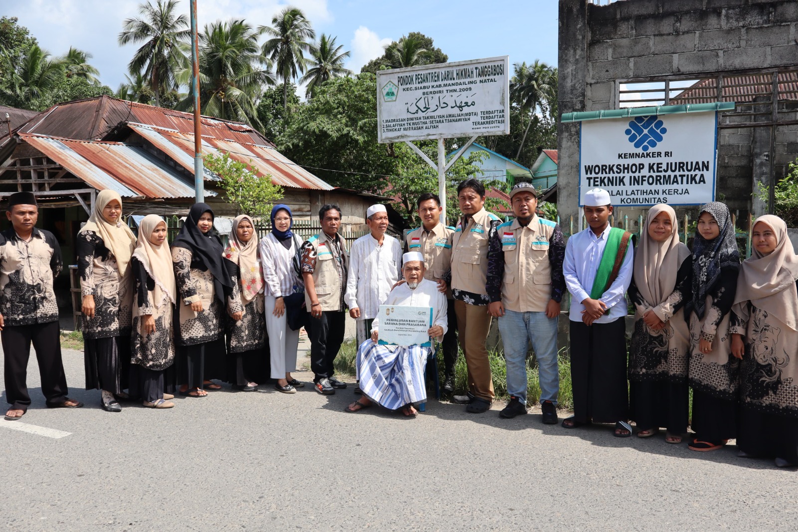 Foto bersama sekaligus penyerahan bantuan dari YBM PLN kepada Yayasan Pondok Pesantren Salafiyah Darul Hikmah Mandailing Natal yang diterima langsung oleh Ketua Yayasan Pondok Pesantren Salafiyah Darul Hikmah Mandailing Natal.