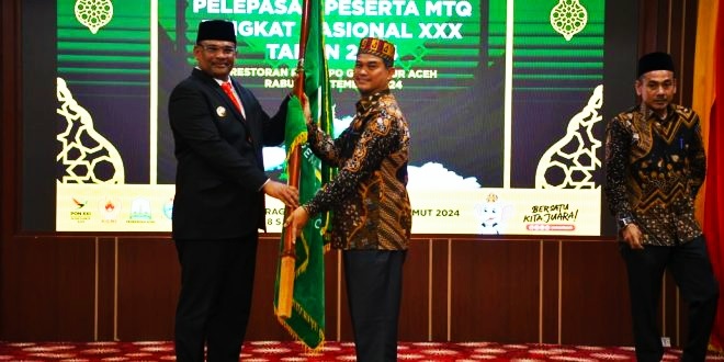 Pj. Gubernur Aceh, Safrizal ZA, menyerahkan pataka kepada Kadis Syariat Islam Aceh, Zahrol Fajri, selaku Ketua Kafilah MTQ Aceh saat melepas keberangkatan kafilah Aceh untuk mengikuti ajang MTQ tingkat nasional ke-30 yang digelar di Kota Samarinda, Provinsi Kaltim di Pendopo Gubernur Aceh,, Rabu (4/9) malam. (Waspada/Zafrullah)