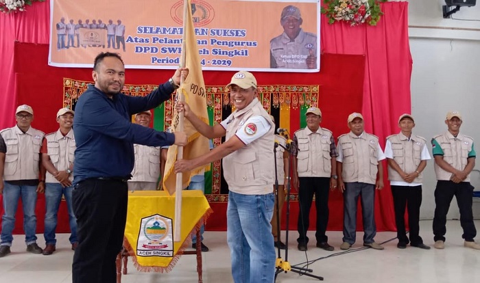 Ketua DPW SWI Aceh melalui Sekretaris Adi Patra menyerahkan bendera Pataka kepada Pengurus DPD SWI Aceh Singkil Yudi Sagala, saat prosesi pelantikan, Senin (9/9/2024). WASPADA/Ariefh