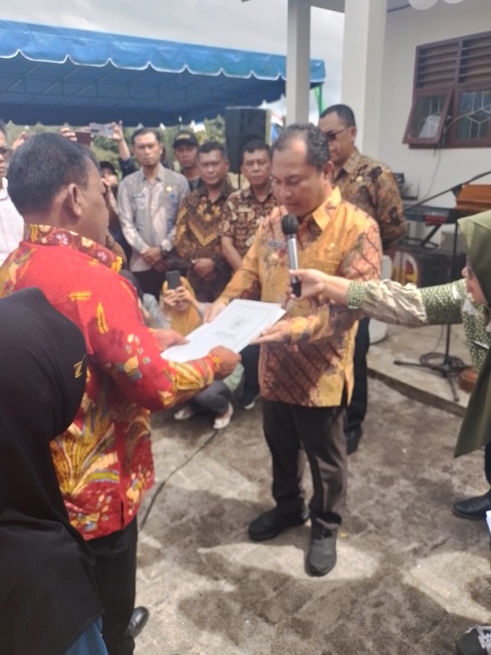 SAUT Ujung (kiri) menyerahkan surat tanah untuk pembangunan SMPN 4 Sidikalang kepada Pj Bupati Dairi Surung Charles Bantjin.Waspada/Kartolo Munte.