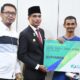 Pj Wali Kota Langsa, Dr (C) Syaridin SPd, MPd didampingi Kepala BPJS Ketenagakerjaan Kantor Cabang Kota Langsa, Muhammad Kurniawan saat menyerahkan kartu peserta BPJS Ketenagakerjaan di ruang kerja wali kota, Kamis (12/9). Waspada/ist