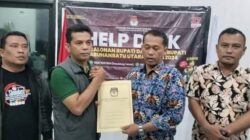 Ketua KPU Labura Adi Susanto serahkan berkas berita acara kepada anggota Bawaslu Labura Juskanri Sihaloho, Minggu (21/9) dinihari.