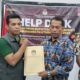 Ketua KPU Labura Adi Susanto serahkan berkas berita acara kepada anggota Bawaslu Labura Juskanri Sihaloho, Minggu (21/9) dinihari.
