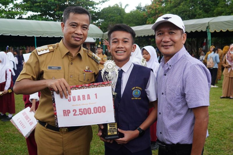 Pj Wali Kota Tebingtinggi, Dr Moettaqien Hasrimi, S.STP, M.Si saat memberikan penghargaan kepada siswa berpeestasi OSN O2SN FLS2SN tingkat kota. Waspada/Ist