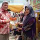 Sekdakab Aceh Utara Dayan Albar menyerahkan pangan subsidi kepada petani di Kecamatan Syamtalira Aro, Kamis (26/9). Waspada/Zainal Abidin