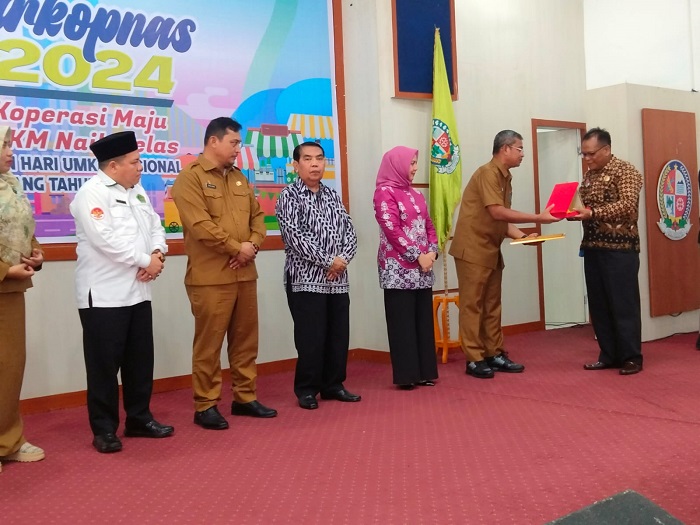 Pj.Bupati Deliserdang Ir.Wiriya Alrahman, MM, menyerahkan penghargaan kepada Ketua Dekopinda Deliserdang Zulkifli Utama, SE, pada Hari Koperasi ke 77 dan Hari UMKM Nasional di Balairung Pemkab Deliserdang, Selasa (3/9). (Waspada/Khairul K Siregar/B).