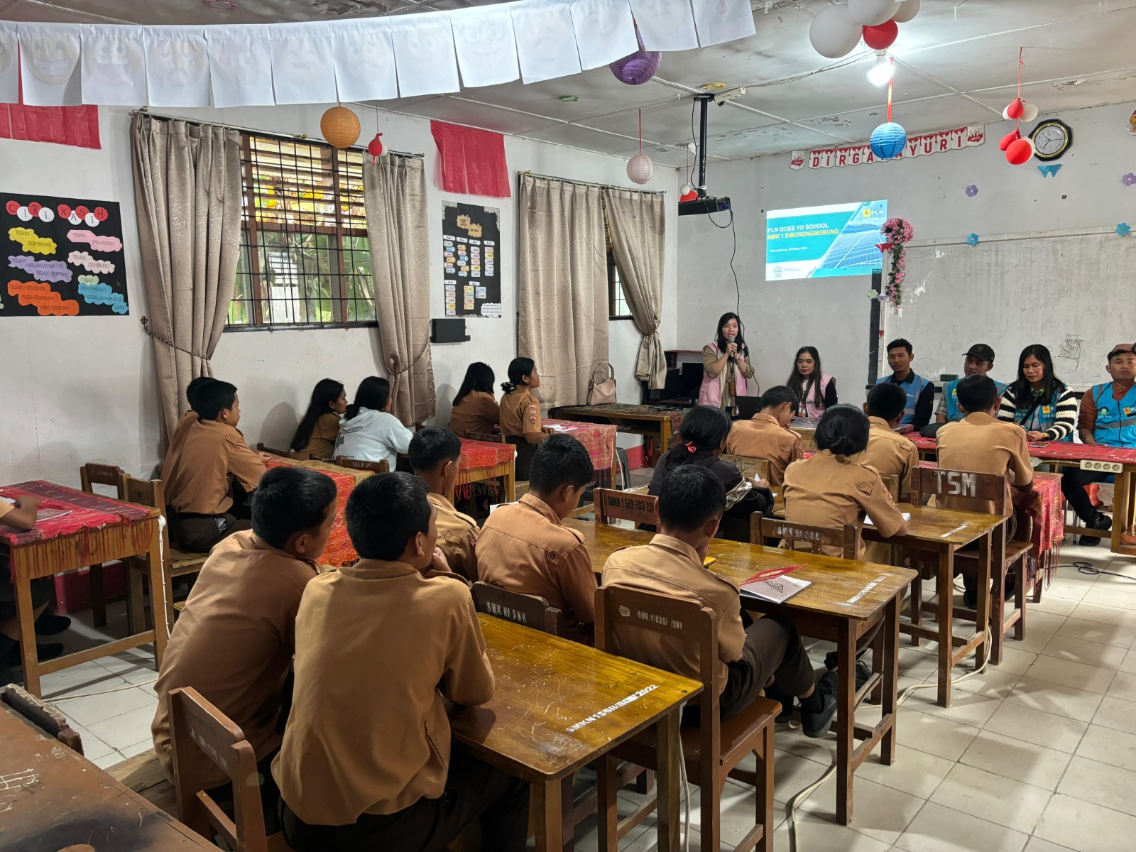 Srikandi PLN ULP Siborong-borong sedang menjelaskan bahaya listrik kepada siswa-siswi SMK Negeri 1 Siborong-borong di Desa Pohan Tonga, Kecamatan Siborong-borong, Kabupaten Tapanuli Utara, Rabu (2/10).