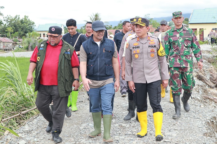 Pj Bupati Agara Taufik di tengah, saat sedang meninjau lokasi banjir. Waspada/Seh Muhammad Amin