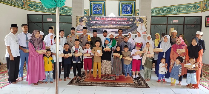 Wakapolres Simalungun Kompol Hendrik Situmorang foto bersama dengan jamaah peserta acara Maulid Nabi Muhammad SAW serta penyerahan bingkisan kepada anak yatim, Selasa (8/10).(Waspada/ist).